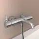 Chromene Badearmatur von Ideal Standard, montiert an einer Wand, mit einer klaren Linie und einem seitlichen Hebel zur Temperatur- und Wassermengenregelung.